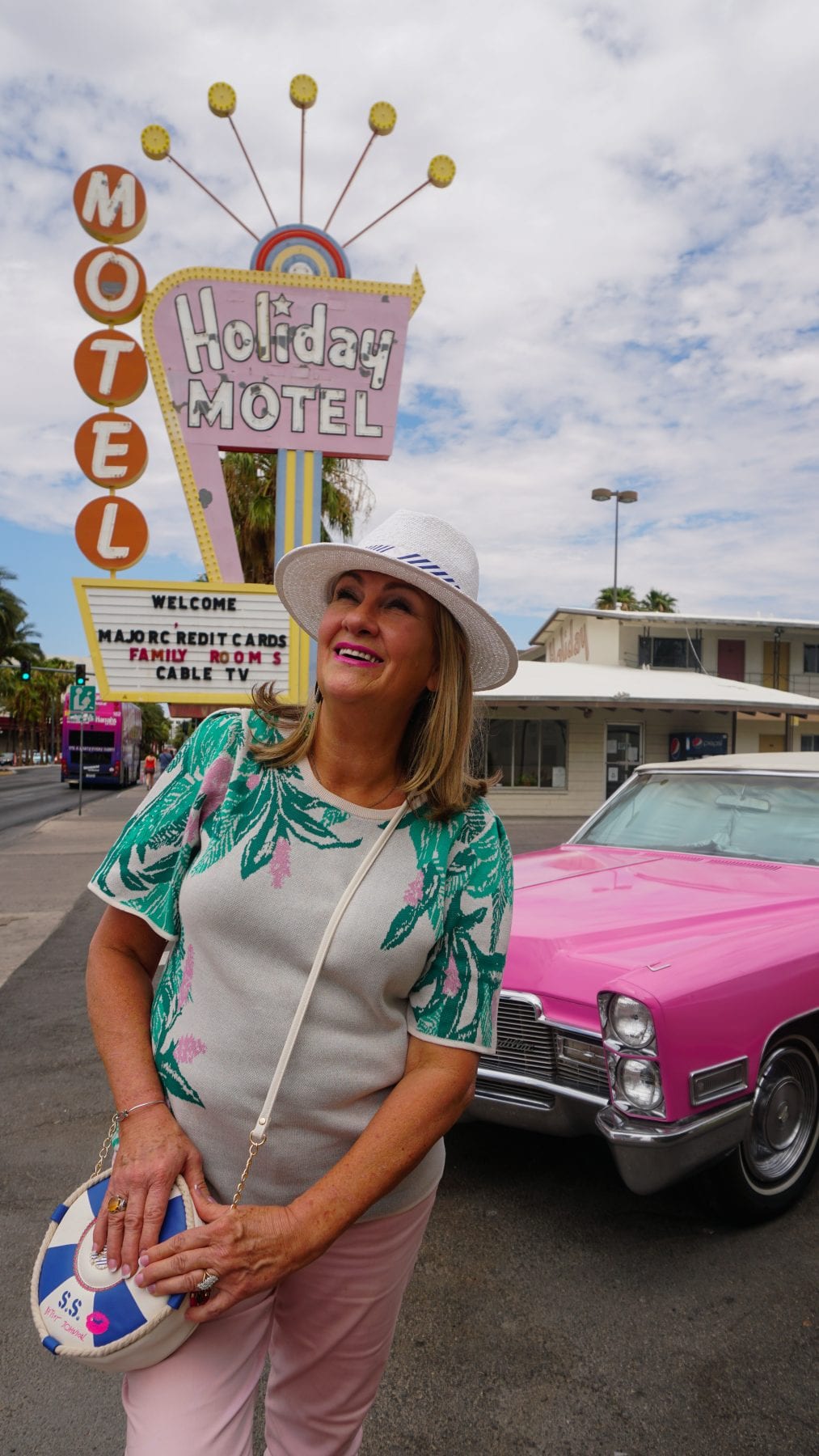 Pink Cadillac At Las Vegas Strip Wedding Chapel At Holiday Motel Las Vegas Best Travel Blog Blogger Pamela Reeves Wearing Banana Republic Pink Jeans Palm Sweater Betsey Johnson Life Buoy Crossbody Purse Handbag, Pameal Davis Reeves, Pam Reeves, Pamela Reeves, Miami, Pam Reeves Davis, Pamela Davis, Pam Davis, Travel Blogger,